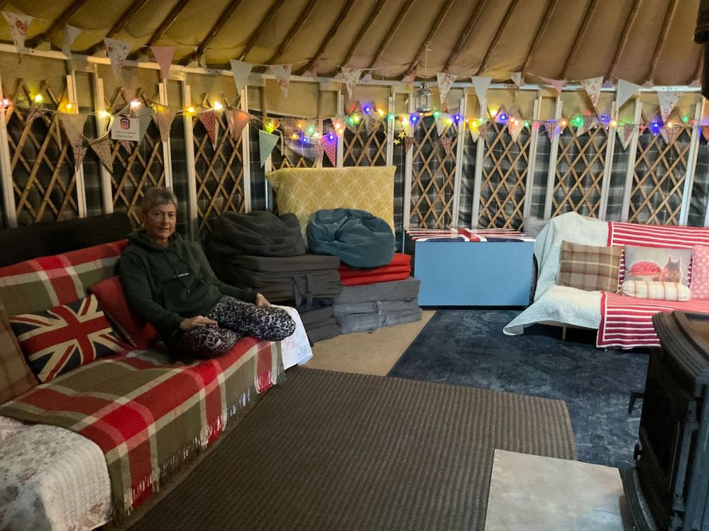 Rachel in her cozy 21-foot tall yurt that sleeps 10 guests.