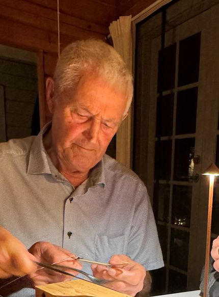 - My 85-year-old father, fixing a very old large fishing hook for catching pike.