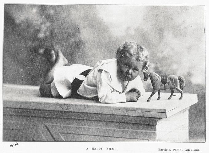 Showing a young boy lying on a wall? with a toy horse -18 December 1902