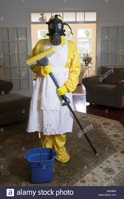 mature-woman-in-yellow-haz-mat-suir-and-gas-mask-standing-in-living-JM638W.jpg